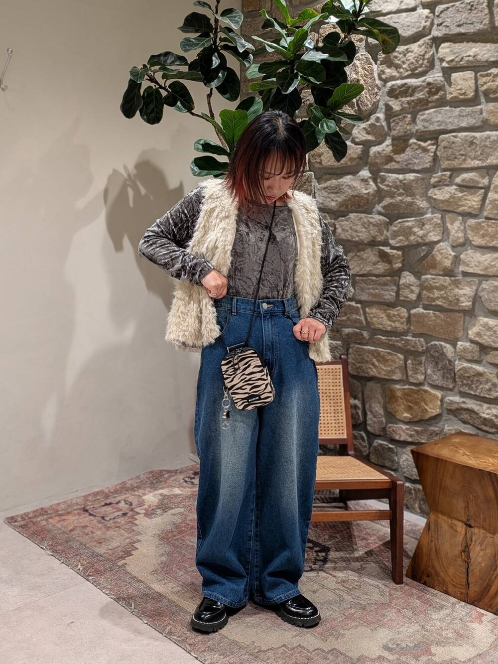 ベージュ系のショルダーバッグ、ブルー系のデニムパンツ、グレー系のTシャツ/カットソーを着用したレディースの冬コーディネートの2枚目の写真