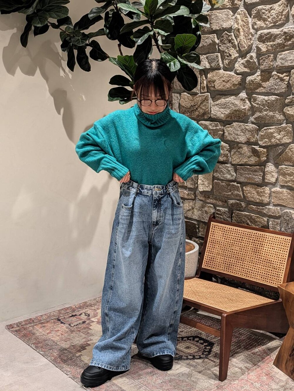 ブラック系のスニーカー、グリーン系のニット/セーター、ブラック系のその他アウターを着用したレディースの冬コーディネートの3枚目の写真