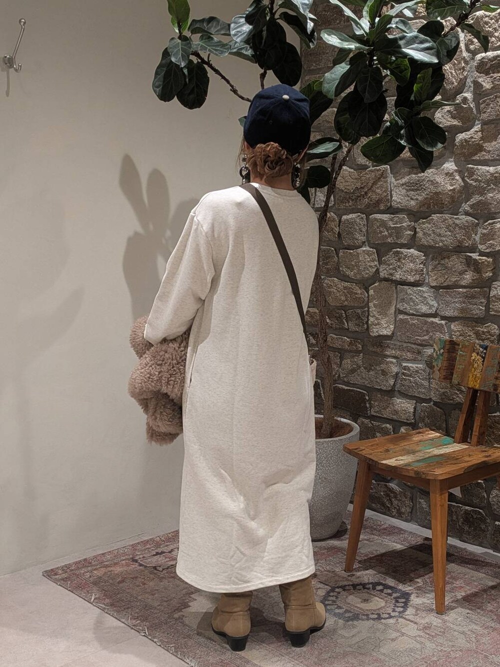 ベージュ系のブーツ、ブラウン系のベスト、ホワイト系のトートバッグを着用したレディースの秋コーディネートの5枚目の写真