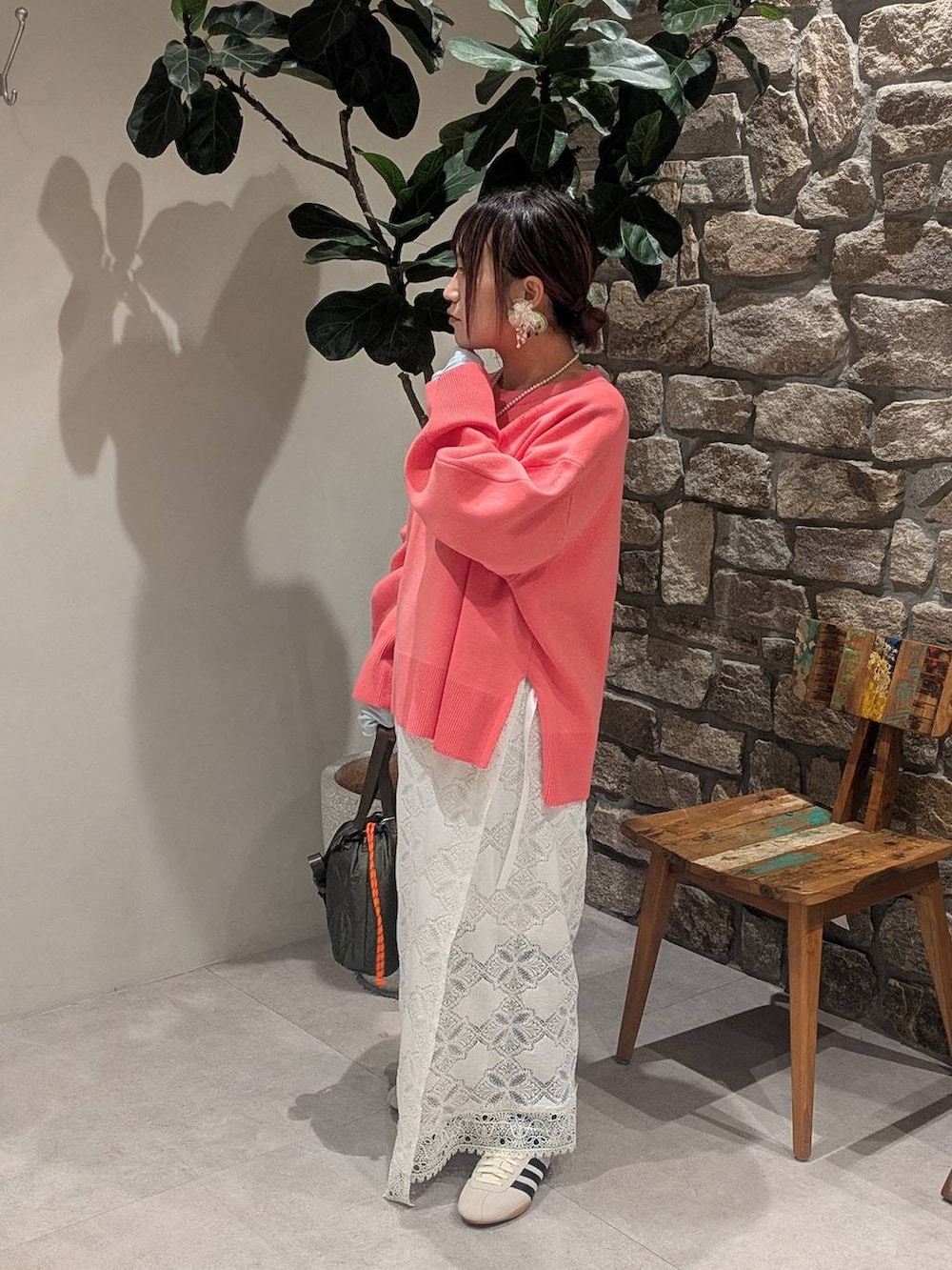 ホワイト系のスニーカー、グリーン系のショルダーバッグ、ピンク系のニット/セーターを着用したレディースの冬コーディネートの2枚目の写真