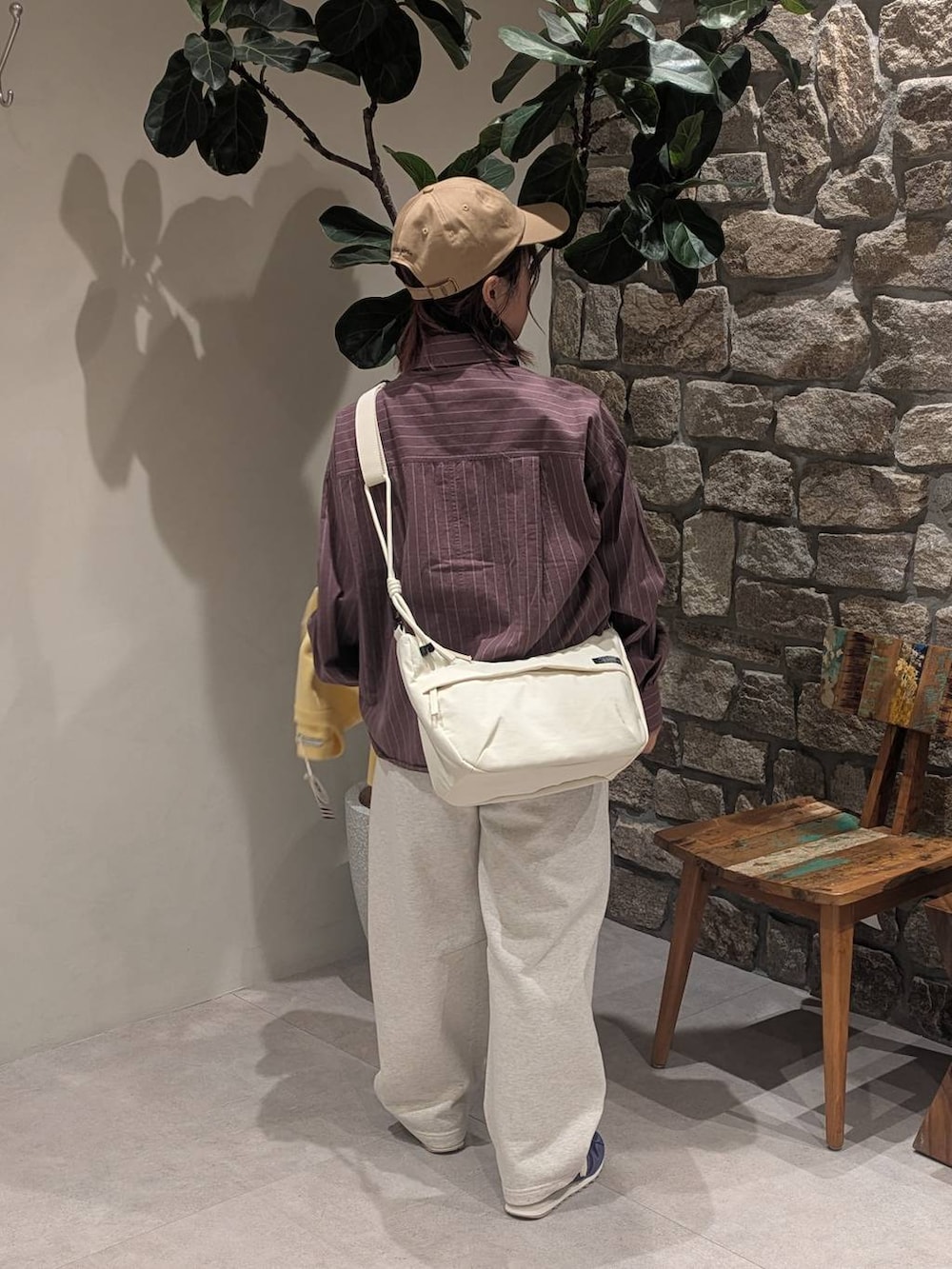 ブルー系のスニーカー、ブラウン系のシャツ/ブラウス、ホワイト系のショルダーバッグを着用したレディースの冬コーディネートの5枚目の写真