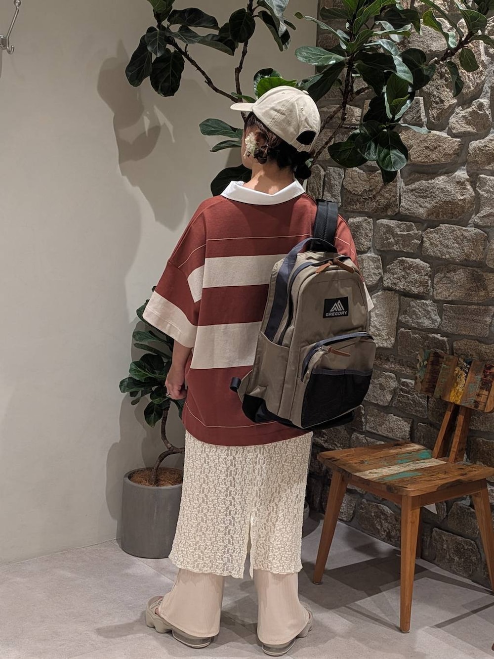 ベージュ系のバックパック/リュック、ブラウン系のポロシャツ、ベージュ系のキャップを着用したレディースの夏コーディネートの3枚目の写真