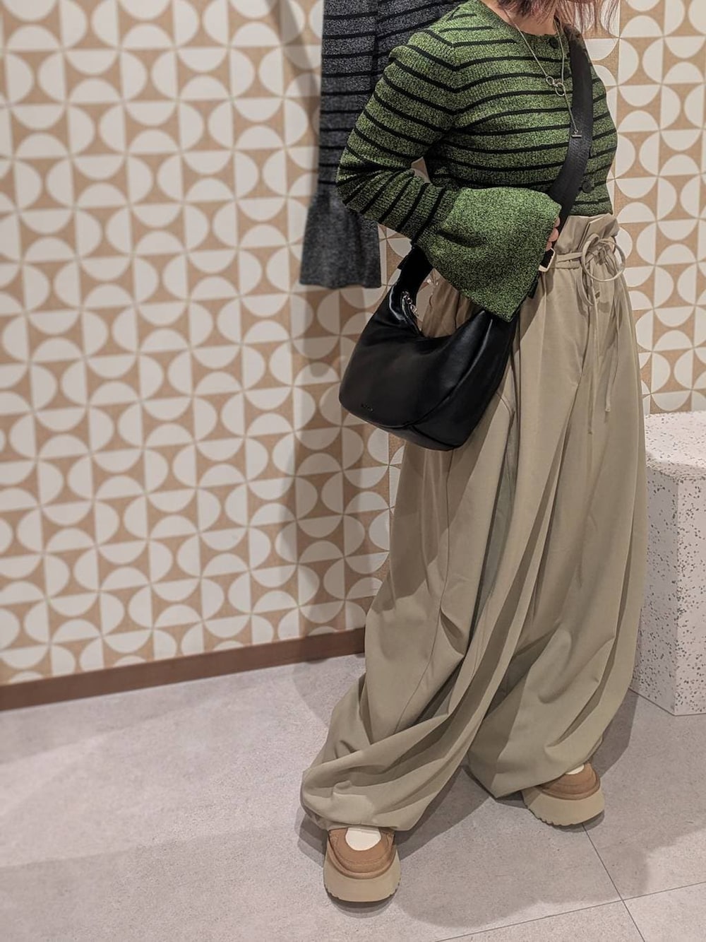 ブラック系のショルダーバッグ、ブラック系のニット/セーター、グリーン系のニット/セーターを着用したレディースの冬コーディネートの5枚目の写真