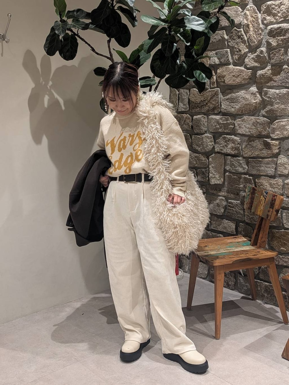 ブラウン系のチェスターコート、ベージュ系のブーツ、ベージュ系のショルダーバッグを着用したレディースの冬コーディネートの5枚目の写真