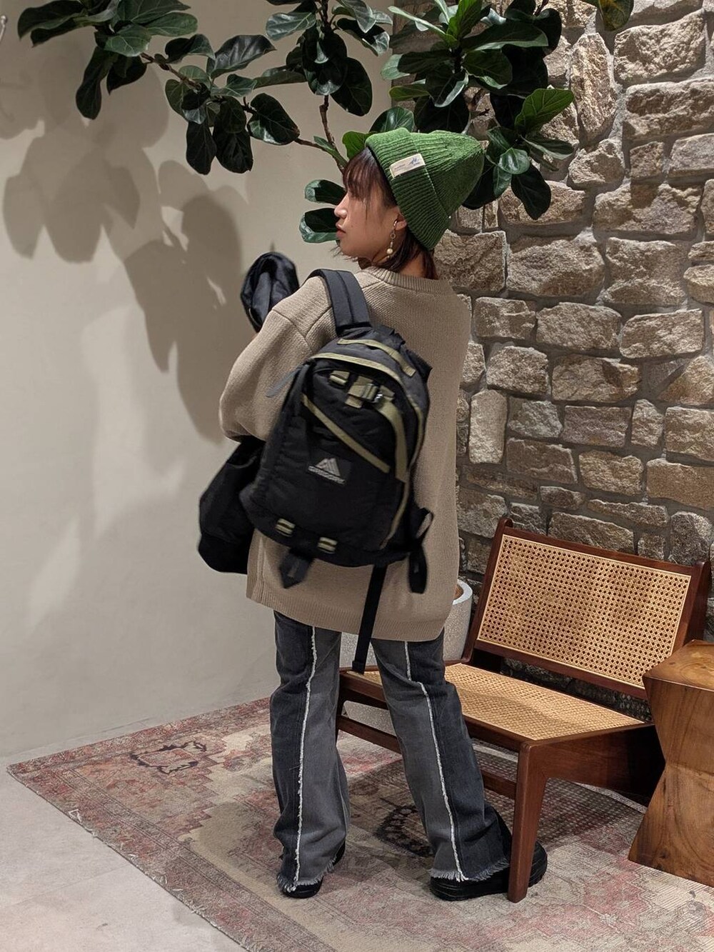 ベージュ系のニット/セーター、ブラック系のデニムパンツ、ブラック系のスニーカーを着用したレディースの冬コーディネートの4枚目の写真