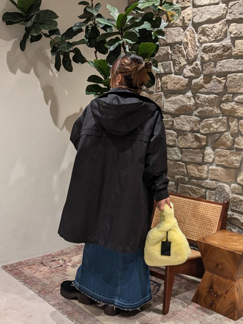 ブルー系のデニムスカート、イエロー系のハンドバッグ、ブルー系のニット/セーターを着用したレディースの冬コーディネートの2枚目の写真