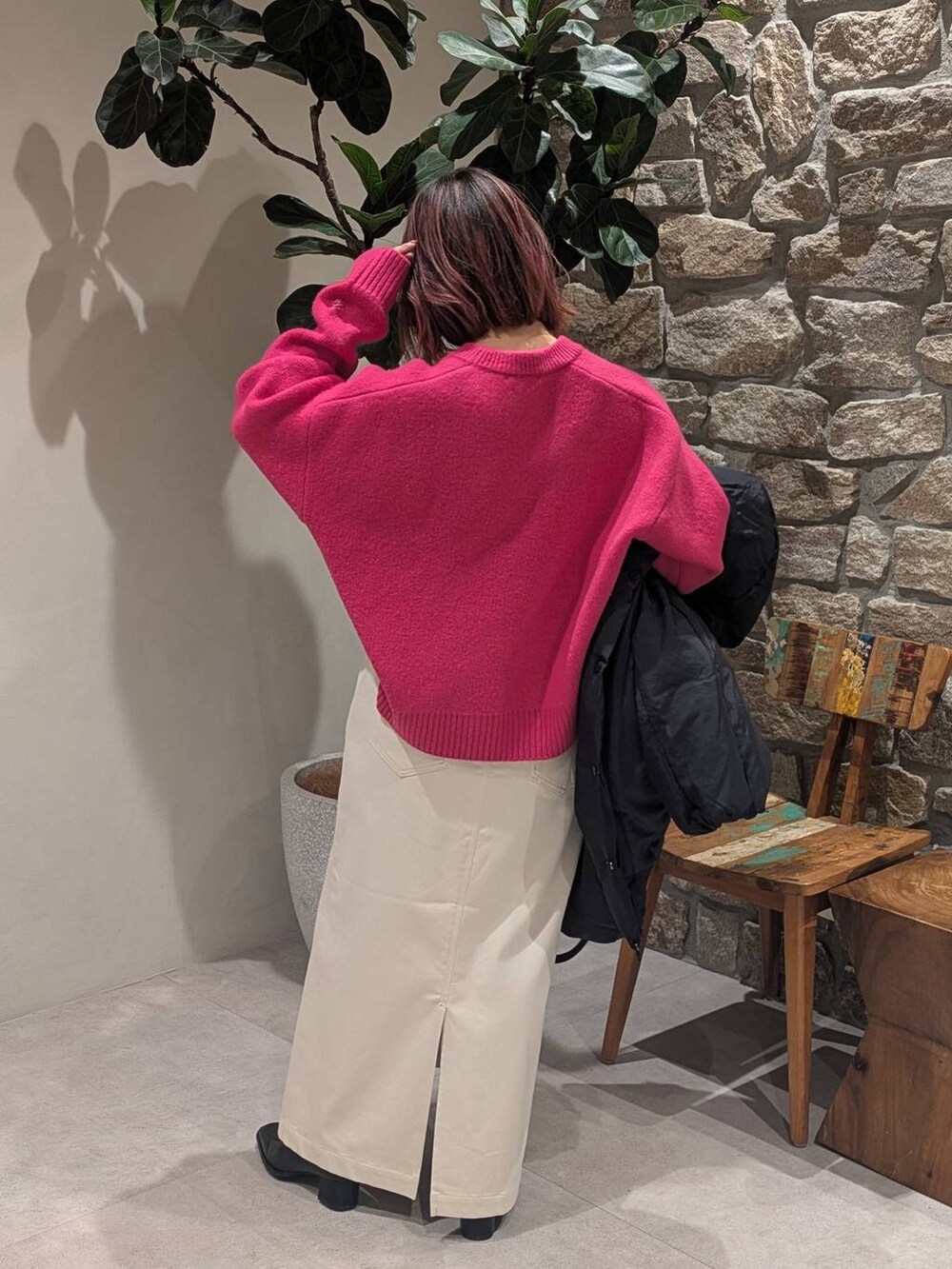 ベージュ系のスカート、ブラック系のブーツ、ブラック系のハンドバッグを着用したレディースの冬コーディネートの4枚目の写真