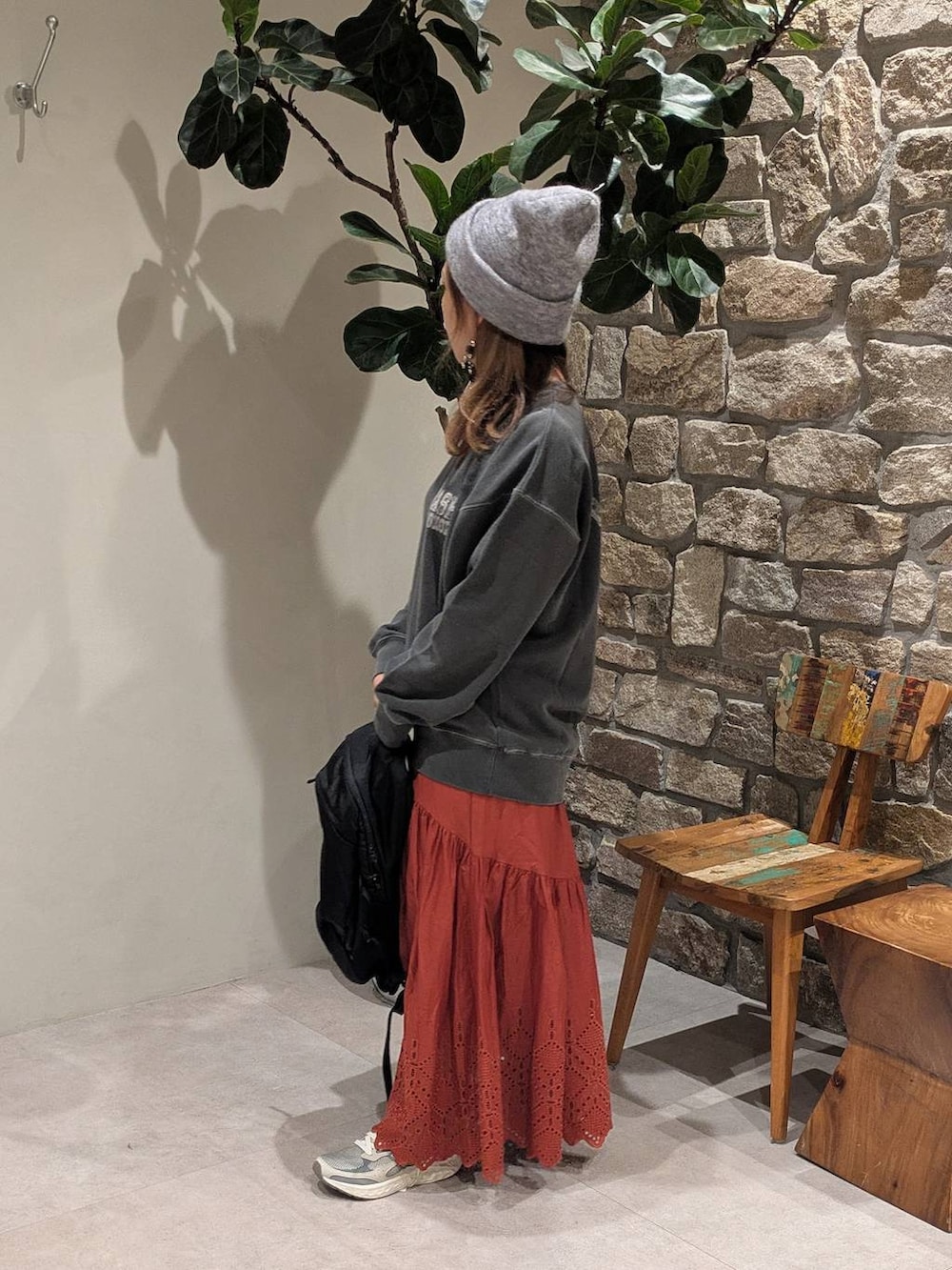 グレー系のスニーカー、ブラック系のバックパック/リュック、グレー系のスウェットを着用したレディースの秋コーディネートの2枚目の写真