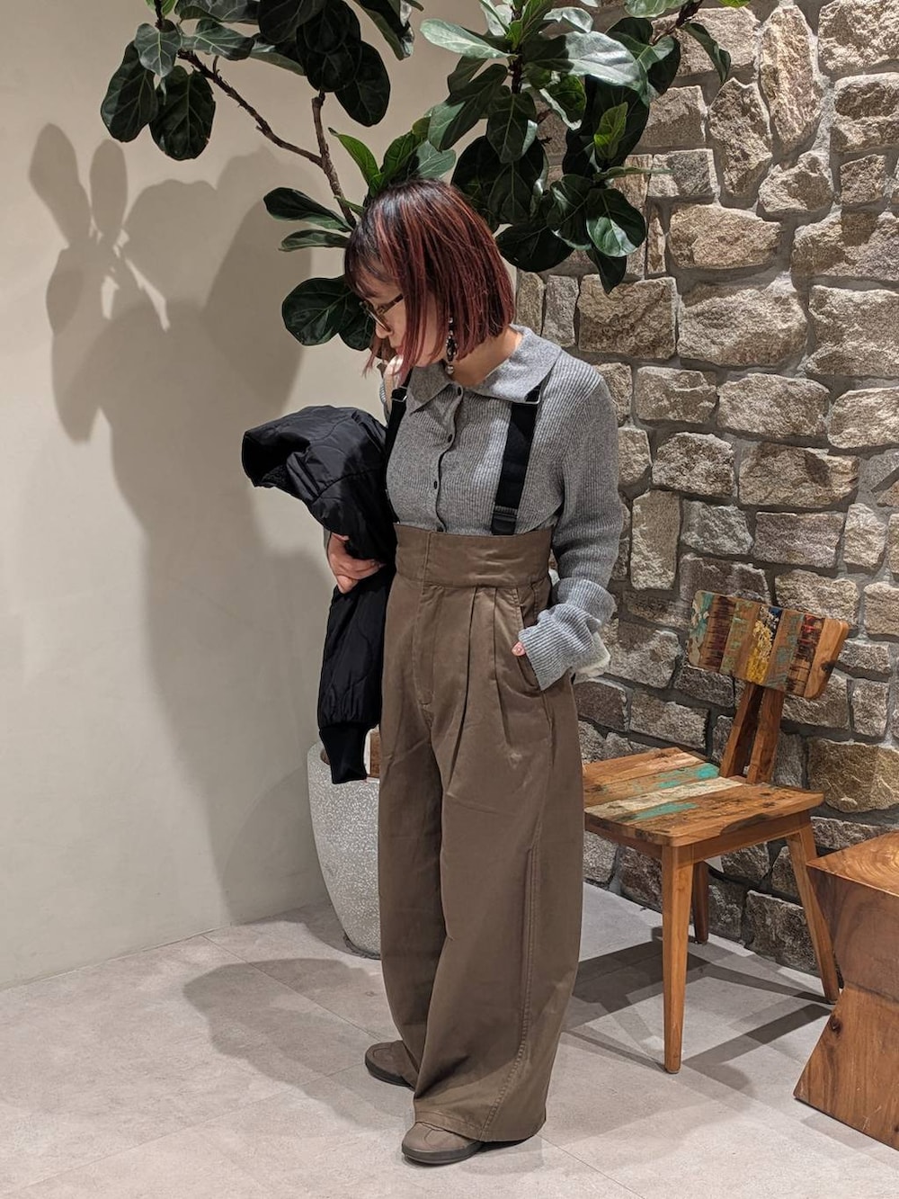 ブラウン系のスニーカー、グレー系のハンドバッグ、ブラック系のブルゾンを着用したレディースの冬コーディネートの2枚目の写真