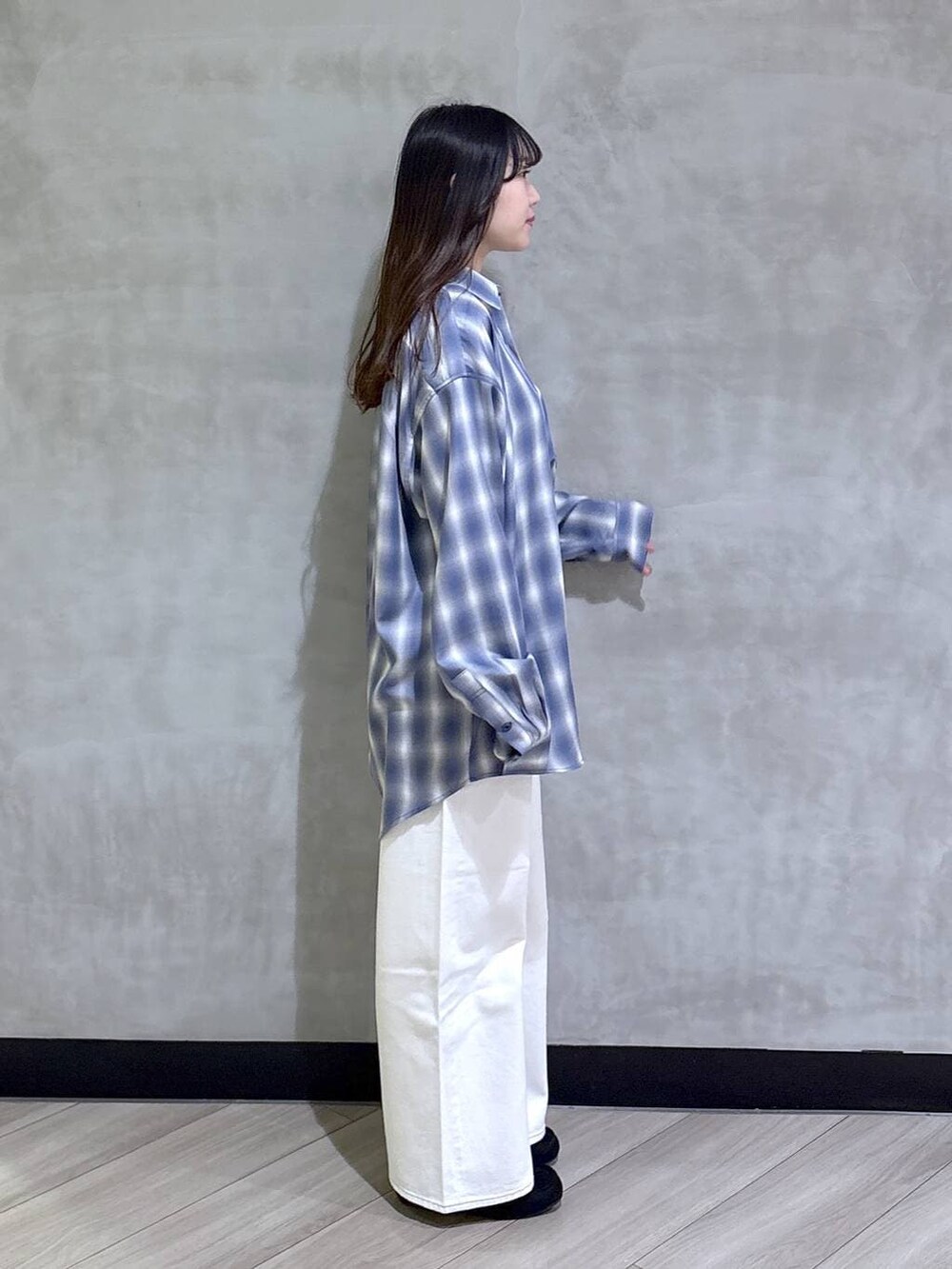 ホワイト系のデニムパンツ、ブラック系のモカシン/デッキシューズ、ブルー系のシャツ/ブラウスを着用したレディースの春コーディネートの6枚目の写真