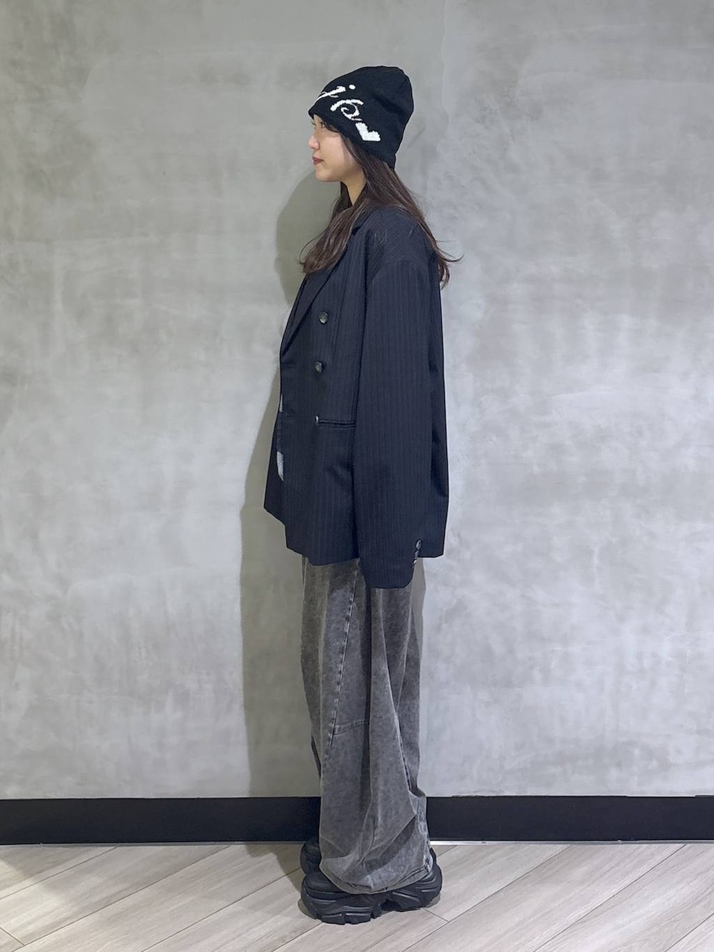 ブラック系のスニーカー、ブラック系のデニムパンツ、ブルー系のテーラードジャケットを着用したレディースの春コーディネートの3枚目の写真