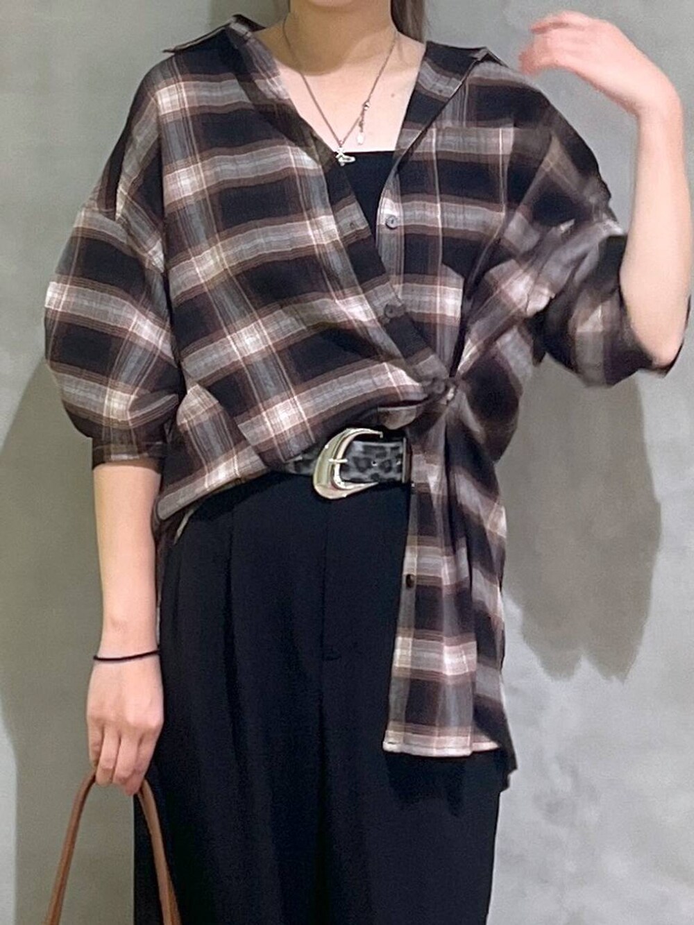 ブラック系のスニーカー、ブラック系のスラックス、ブラウン系のシャツ/ブラウスを着用したレディースの秋コーディネートの2枚目の写真