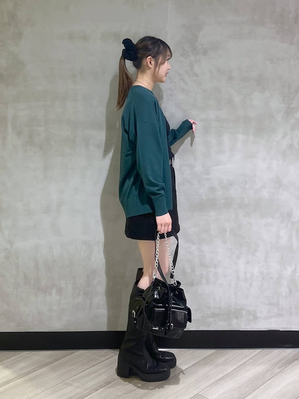 ブラック系のブーツ、ブラック系のスカート、グリーン系のカーディガン/ボレロを着用したレディースの秋コーディネートの8枚目の写真