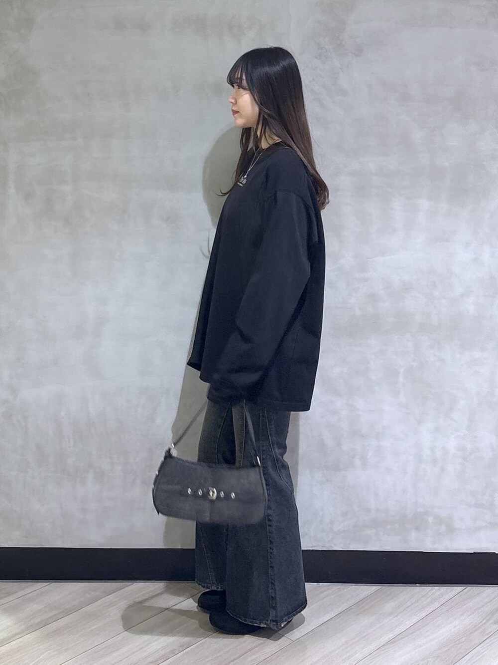 ブラック系のデニムパンツ、ブラック系のモカシン/デッキシューズ、ブラック系のTシャツ/カットソーを着用したレディースの春コーディネートの4枚目の写真