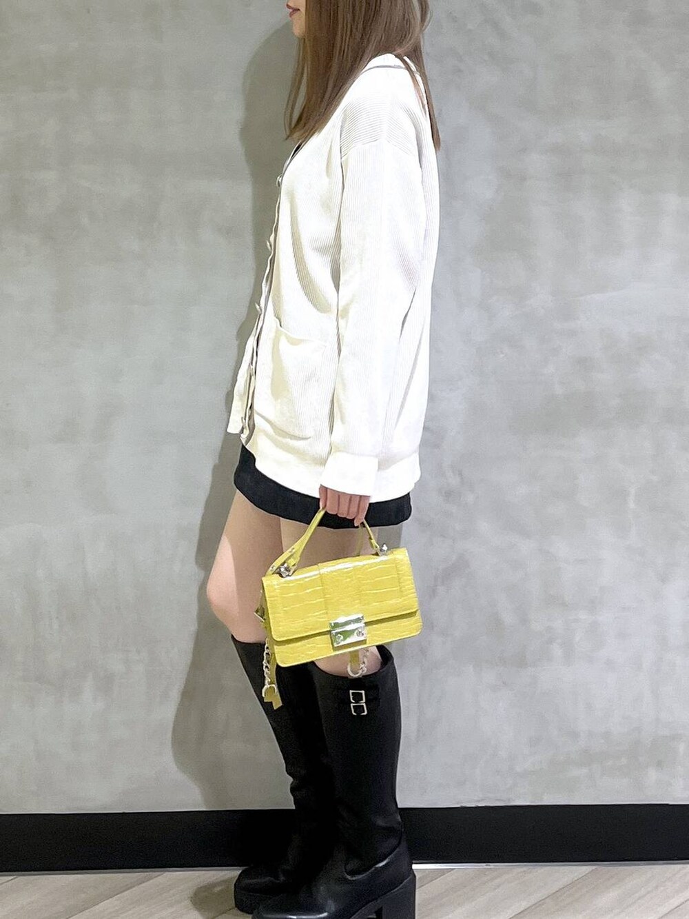 ブラック系のブーツ、ブラック系のスカート、ホワイト系のカーディガン/ボレロを着用したレディースの秋コーディネートの4枚目の写真