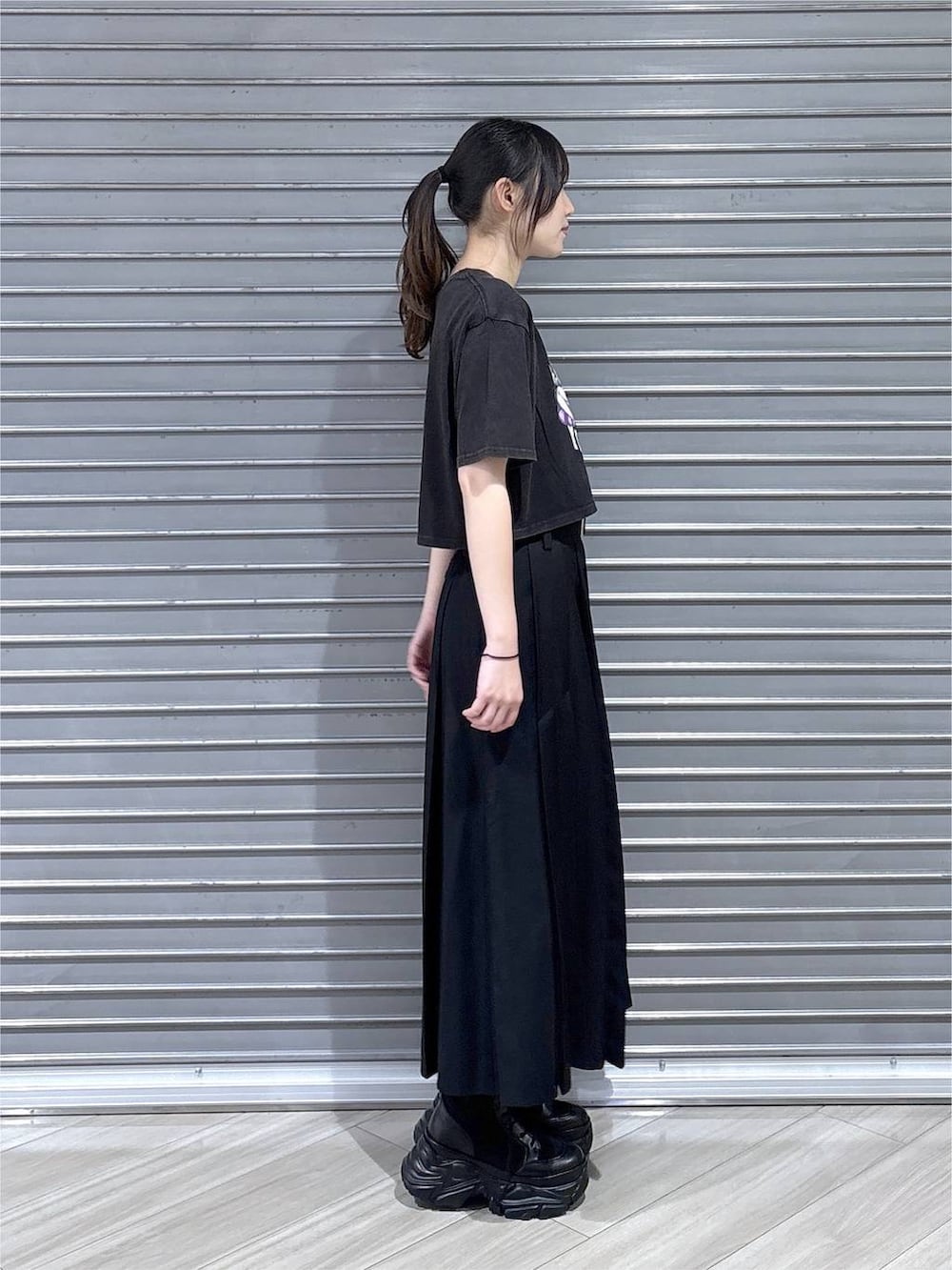 グレー系のTシャツ/カットソー、ブラック系のブーツ、ブラック系のスカートを着用したレディースの夏コーディネートの6枚目の写真