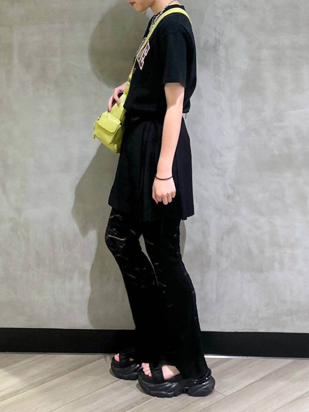 ブラック系のサンダル、ブラック系のスカート、グリーン系のショルダーバッグを着用したレディースの春コーディネートの5枚目の写真