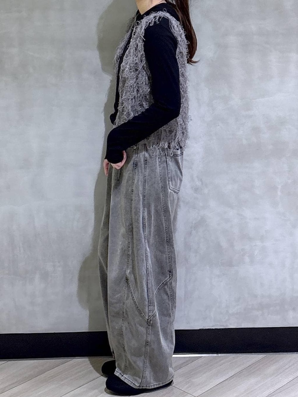 グレー系のベスト、ブラック系のデニムパンツ、ブラック系のTシャツ/カットソーを着用したレディースの春コーディネートの4枚目の写真