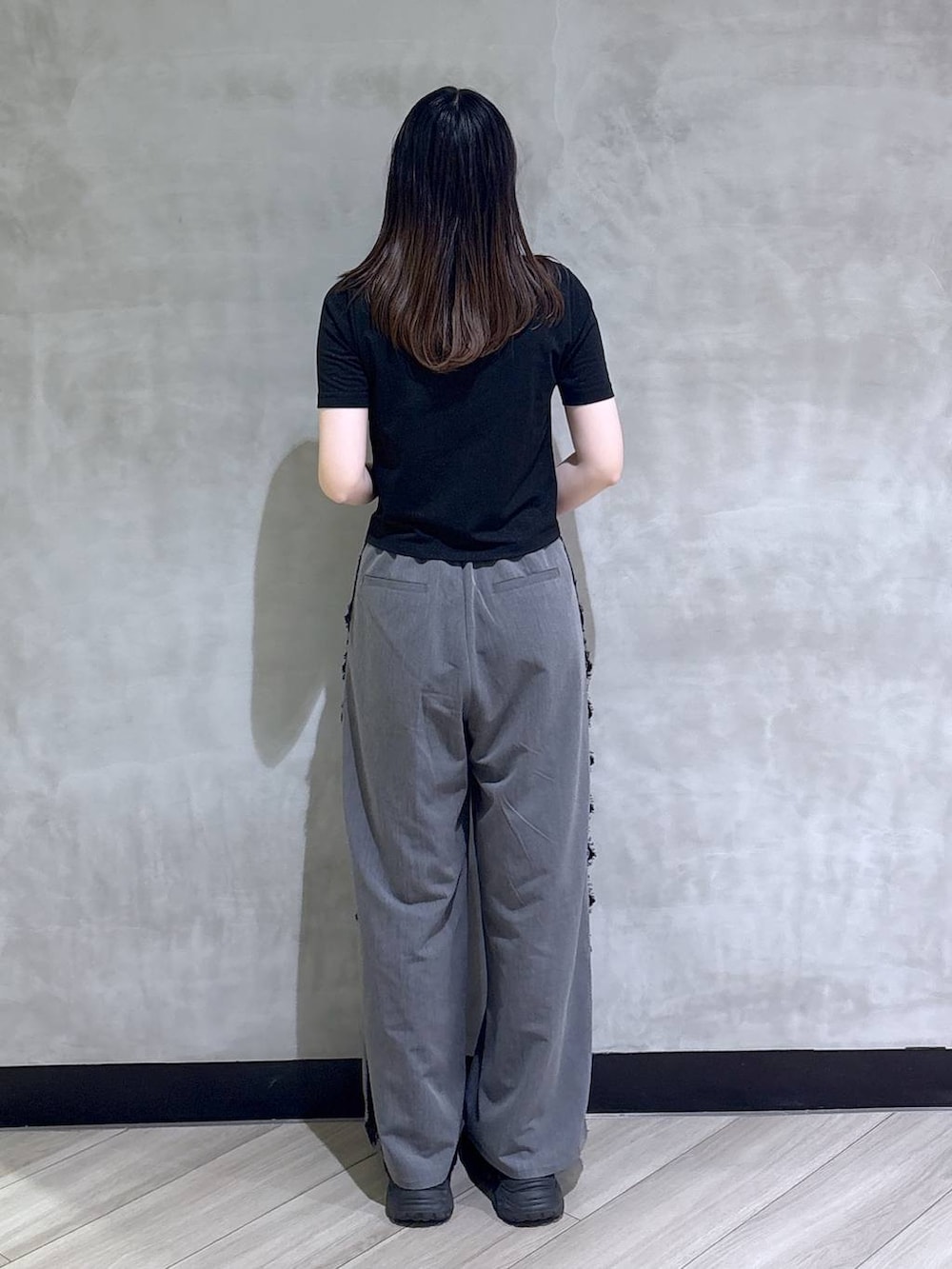 ブラック系のサンダル、グレー系のスラックス、ブラック系のTシャツ/カットソーを着用したレディースの夏コーディネートの5枚目の写真
