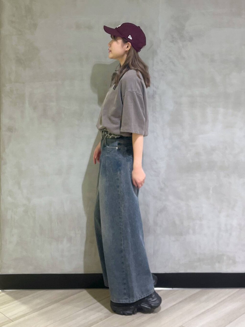 ブルー系のデニムパンツ、ブラウン系のスウェット、シルバー系のスニーカーを着用したレディースの夏コーディネートの2枚目の写真