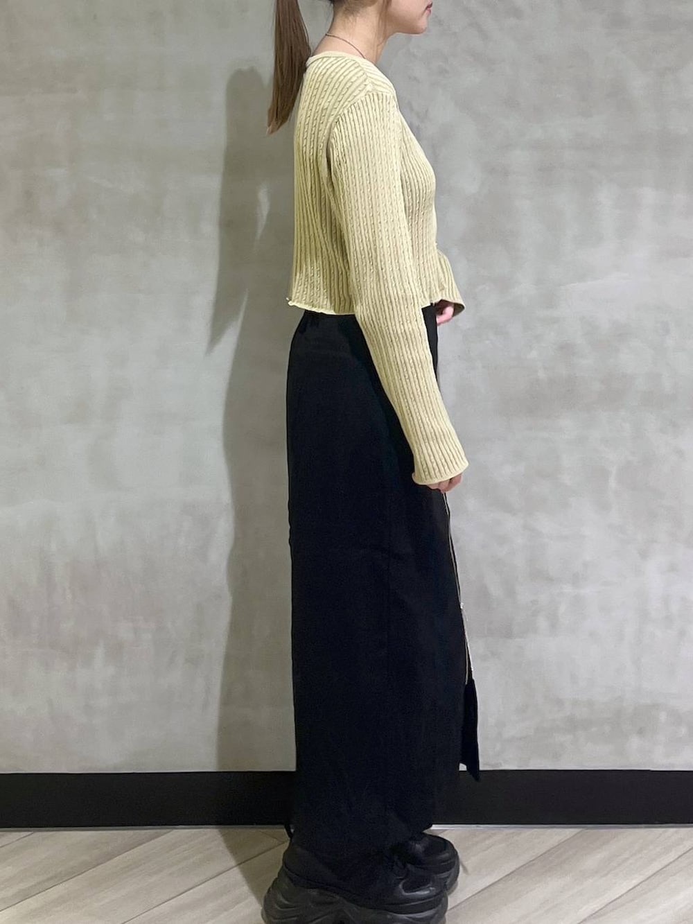 ブラック系のブーツ、イエロー系のカーディガン/ボレロ、ブラック系のスカートを着用したレディースの秋コーディネートの8枚目の写真