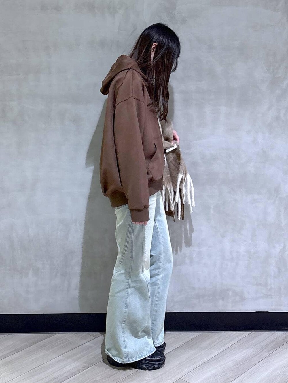 ブルー系のデニムパンツ、ブラック系のパーカー、ブラック系のローファーを着用したレディースの冬コーディネートの7枚目の写真