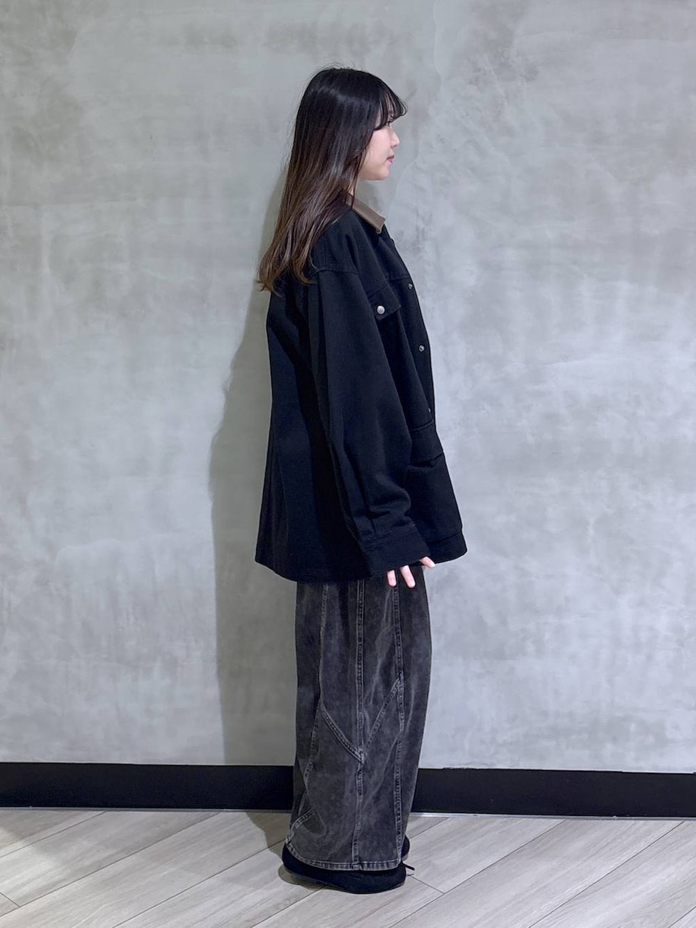 ブラック系のデニムパンツ、ブラック系のモカシン/デッキシューズ、ブラック系のその他アウターを着用したレディースの春コーディネートの6枚目の写真