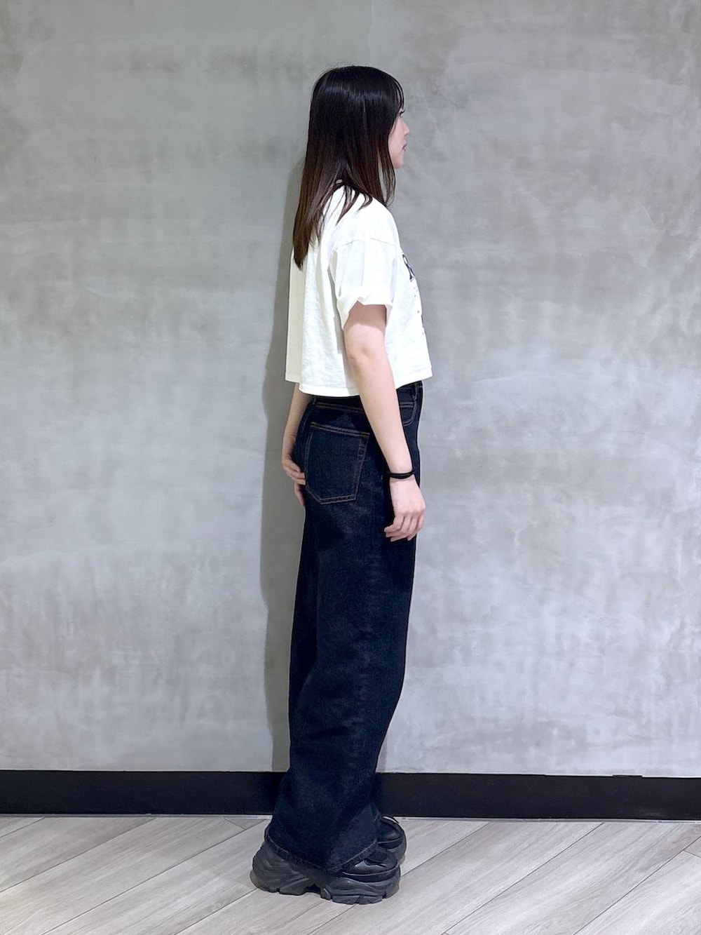 ブラック系のスニーカー、ブルー系のデニムパンツ、ホワイト系のTシャツ/カットソーを着用したレディースの夏コーディネートの6枚目の写真