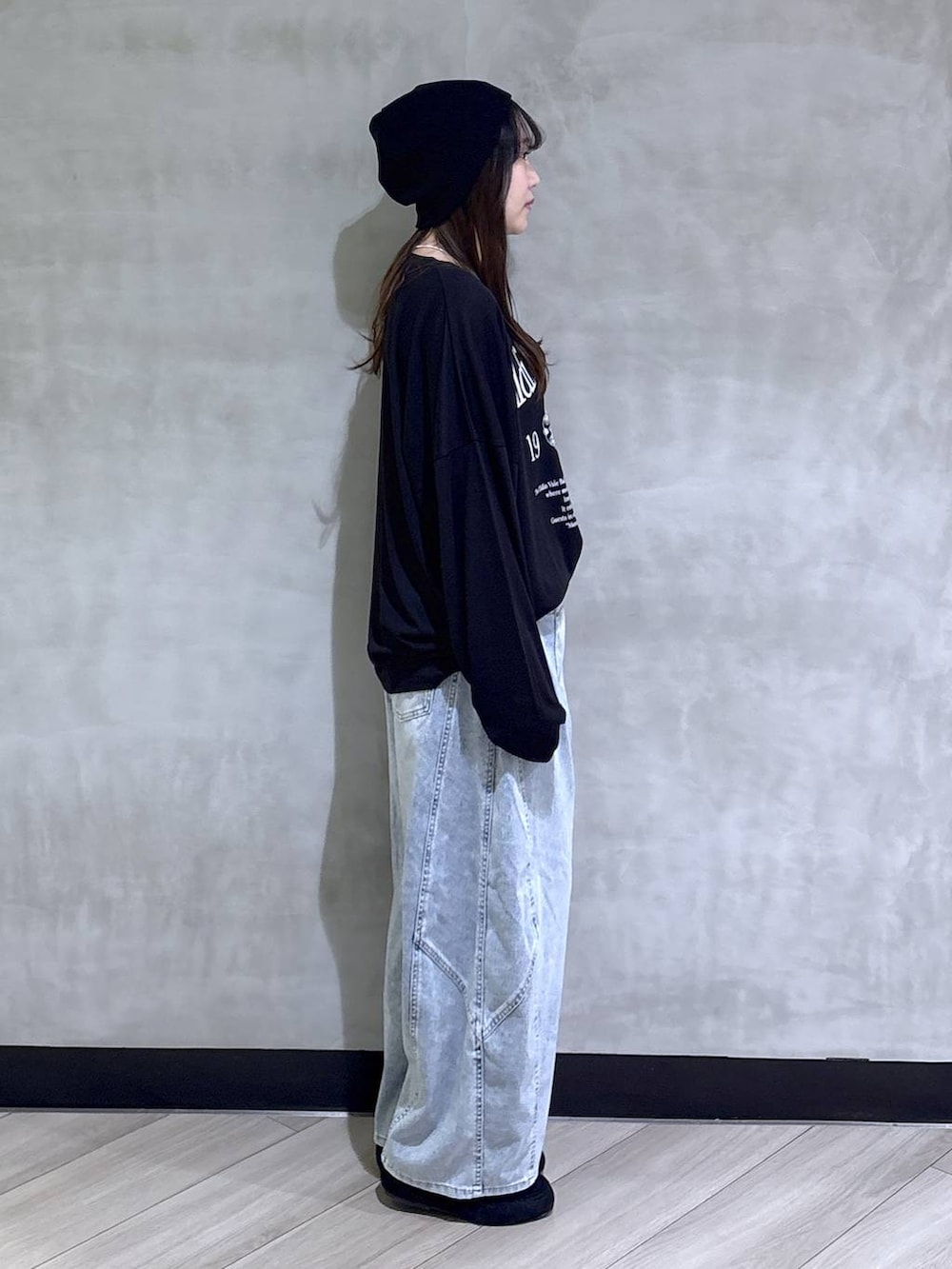 ブルー系のデニムパンツ、ブラック系のモカシン/デッキシューズ、ブラック系のTシャツ/カットソーを着用したレディースの春コーディネートの6枚目の写真