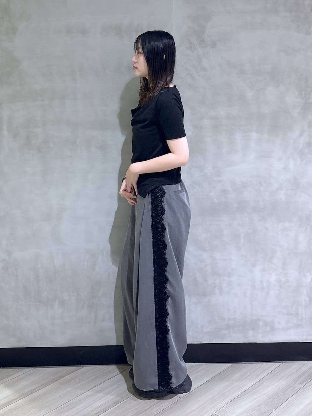 ブラック系のサンダル、グレー系のスラックス、ブラック系のTシャツ/カットソーを着用したレディースの夏コーディネートの3枚目の写真