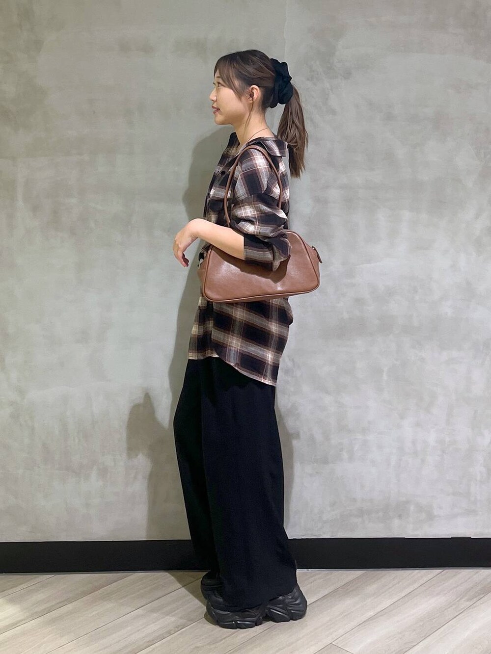 ブラック系のスニーカー、ブラック系のスラックス、ブラウン系のシャツ/ブラウスを着用したレディースの秋コーディネートの5枚目の写真