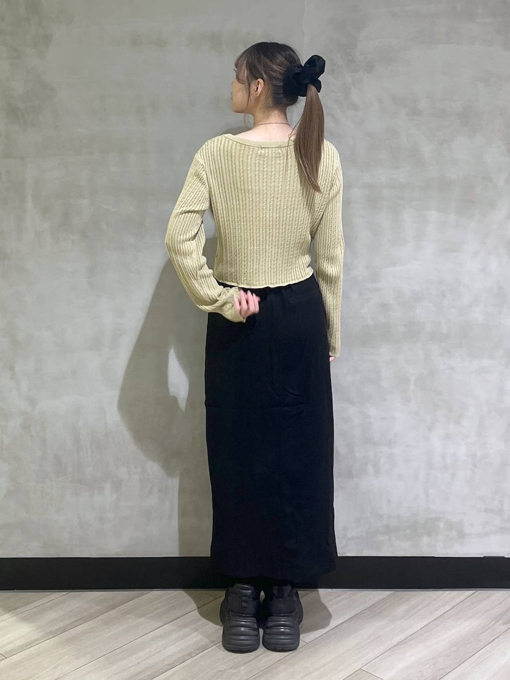 ブラック系のブーツ、イエロー系のカーディガン/ボレロ、ブラック系のスカートを着用したレディースの秋コーディネートの6枚目の写真