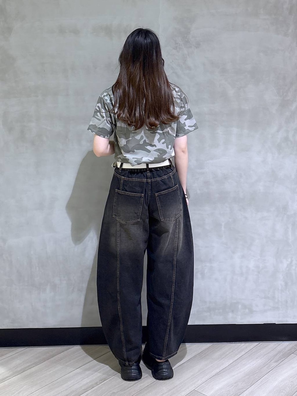 ブラック系のデニムパンツ、グレー系のサンダル、その他のTシャツ/カットソーを着用したレディースの春コーディネートの5枚目の写真