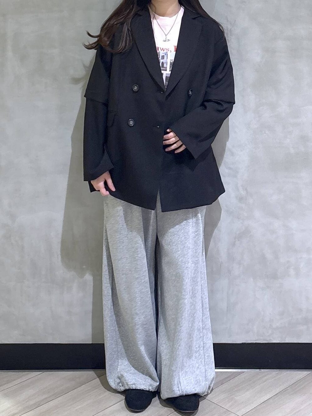 グレー系のスウェットパンツ、ブラック系のテーラードジャケット、ブラック系のモカシン/デッキシューズを着用したレディースの春コーディネートの2枚目の写真