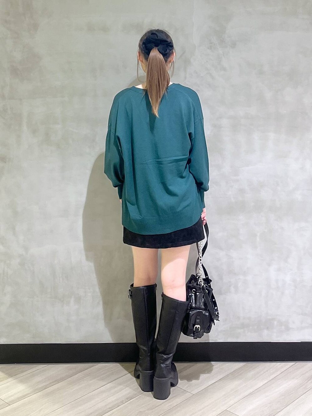 ブラック系のブーツ、ブラック系のスカート、グリーン系のカーディガン/ボレロを着用したレディースの秋コーディネートの6枚目の写真