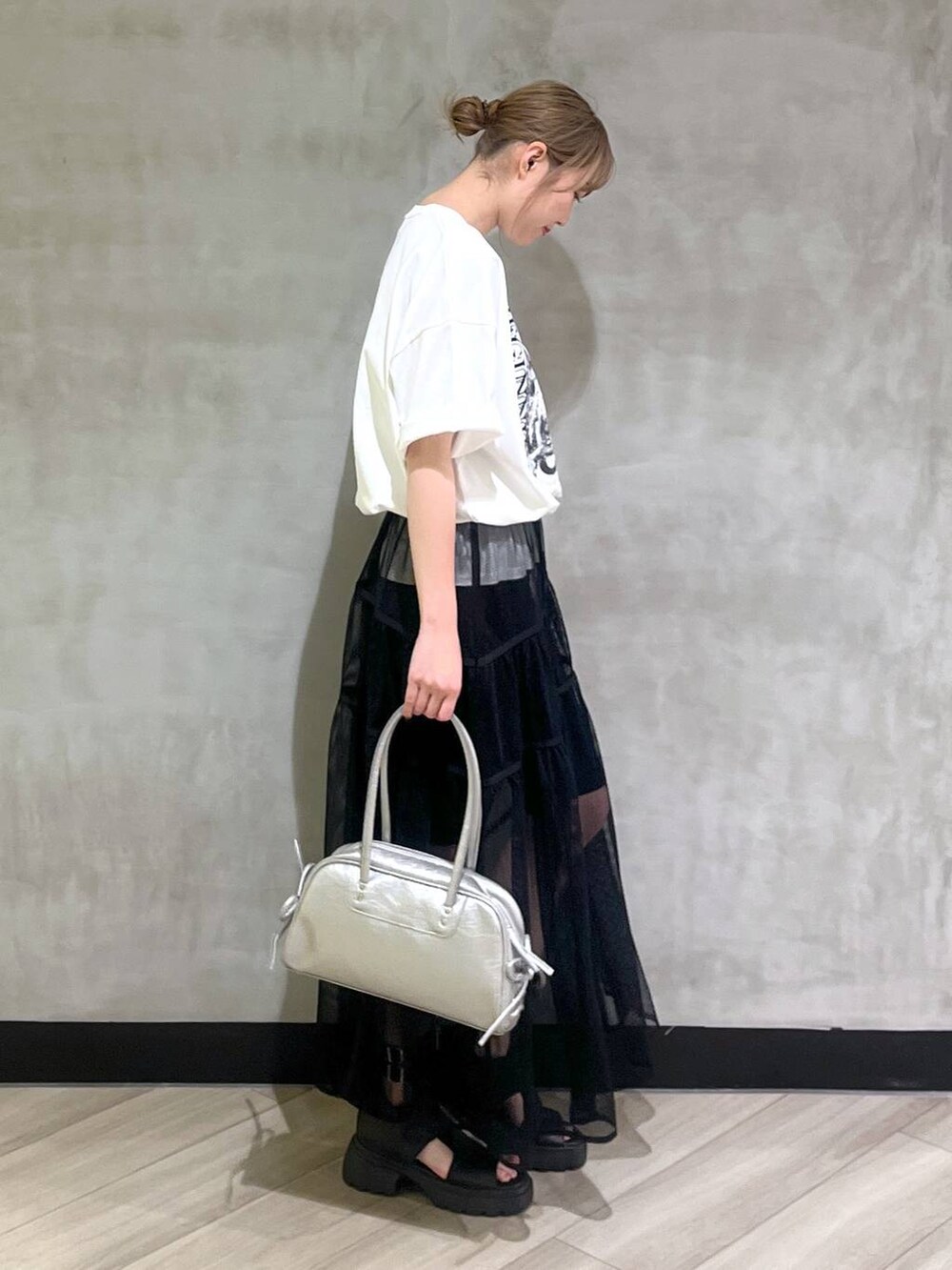 ブラック系のサンダル、シルバー系のショルダーバッグ、ホワイト系のTシャツ/カットソーを着用したレディースの春コーディネートの7枚目の写真