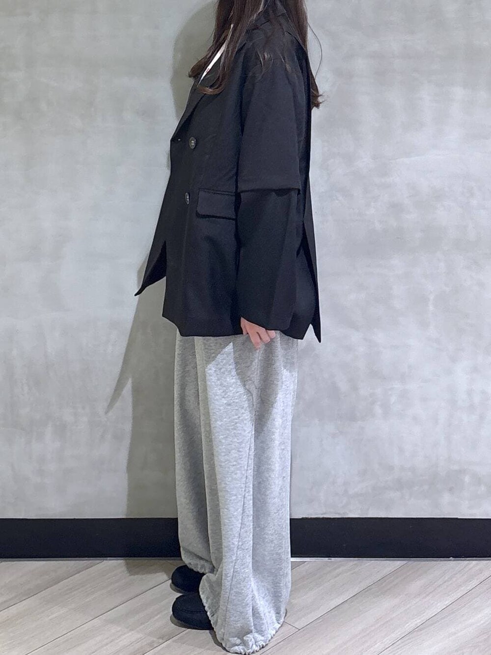 グレー系のスウェットパンツ、ブラック系のテーラードジャケット、ブラック系のモカシン/デッキシューズを着用したレディースの春コーディネートの4枚目の写真