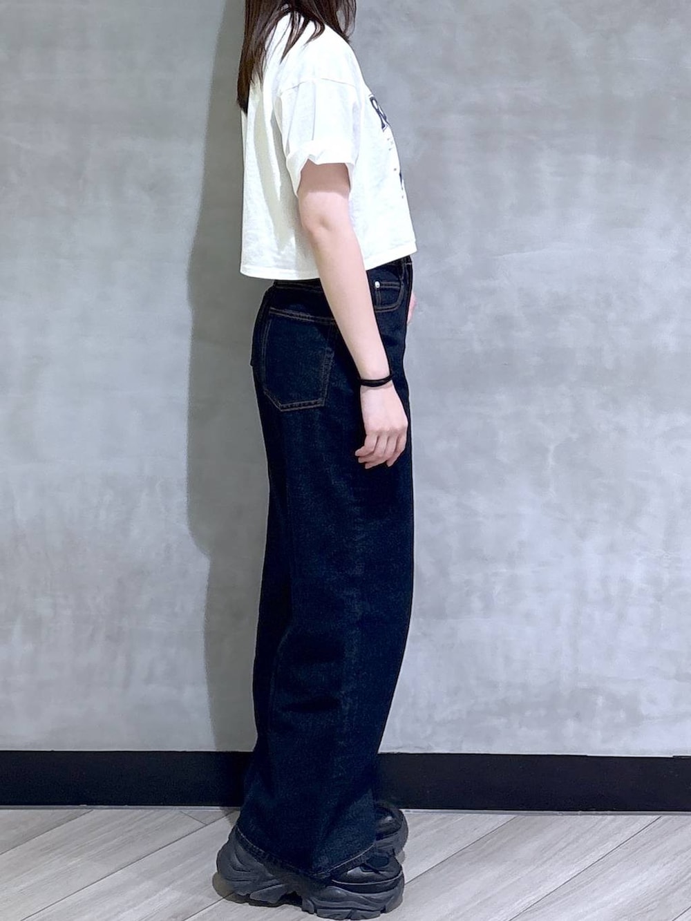 ブラック系のスニーカー、ブルー系のデニムパンツ、ホワイト系のTシャツ/カットソーを着用したレディースの夏コーディネートの7枚目の写真
