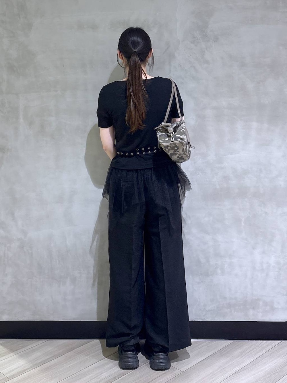 グレー系のサンダル、ブラック系のスラックス、ブラック系のTシャツ/カットソーを着用したレディースの春コーディネートの5枚目の写真