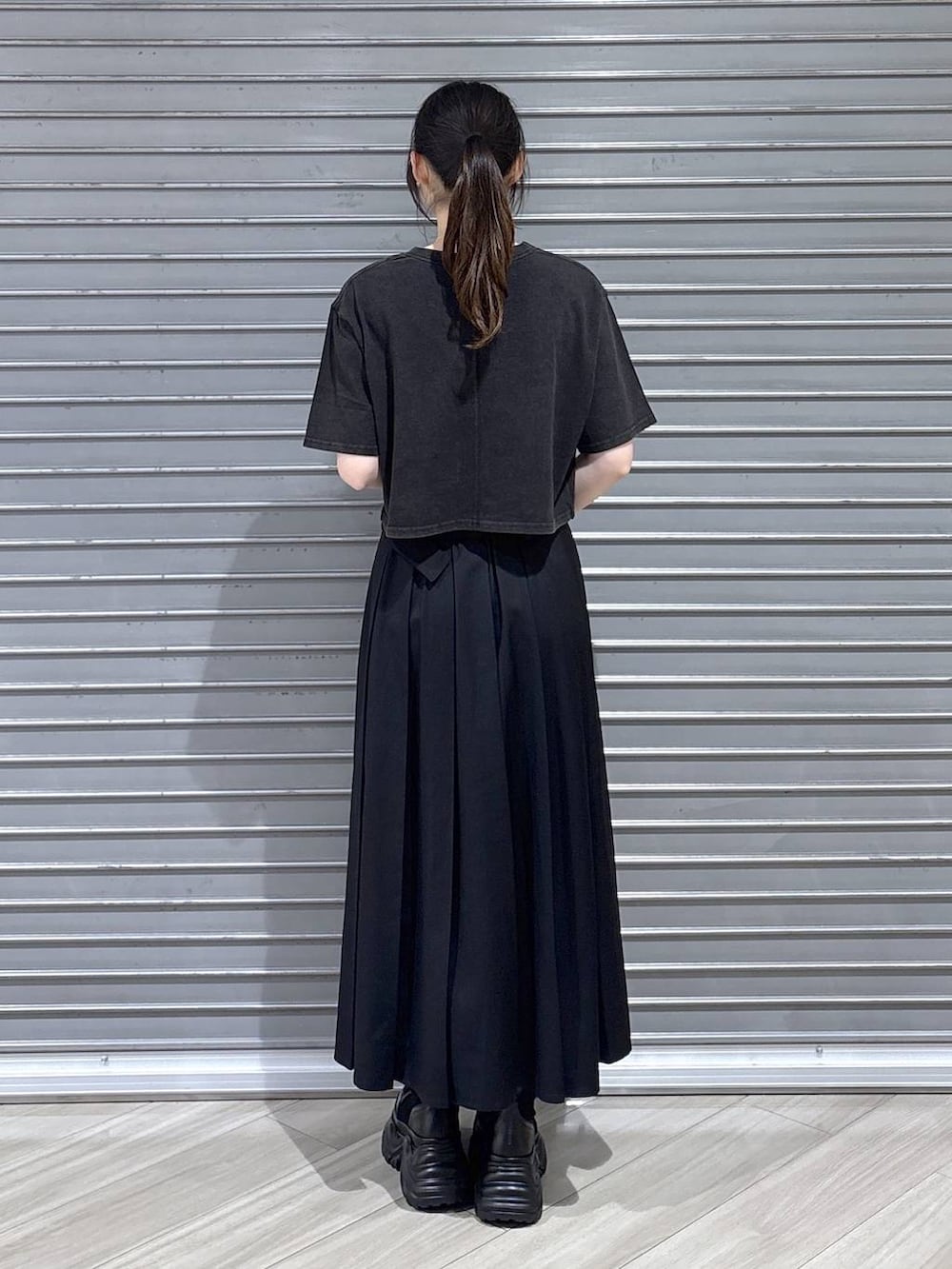 グレー系のTシャツ/カットソー、ブラック系のブーツ、ブラック系のスカートを着用したレディースの夏コーディネートの5枚目の写真