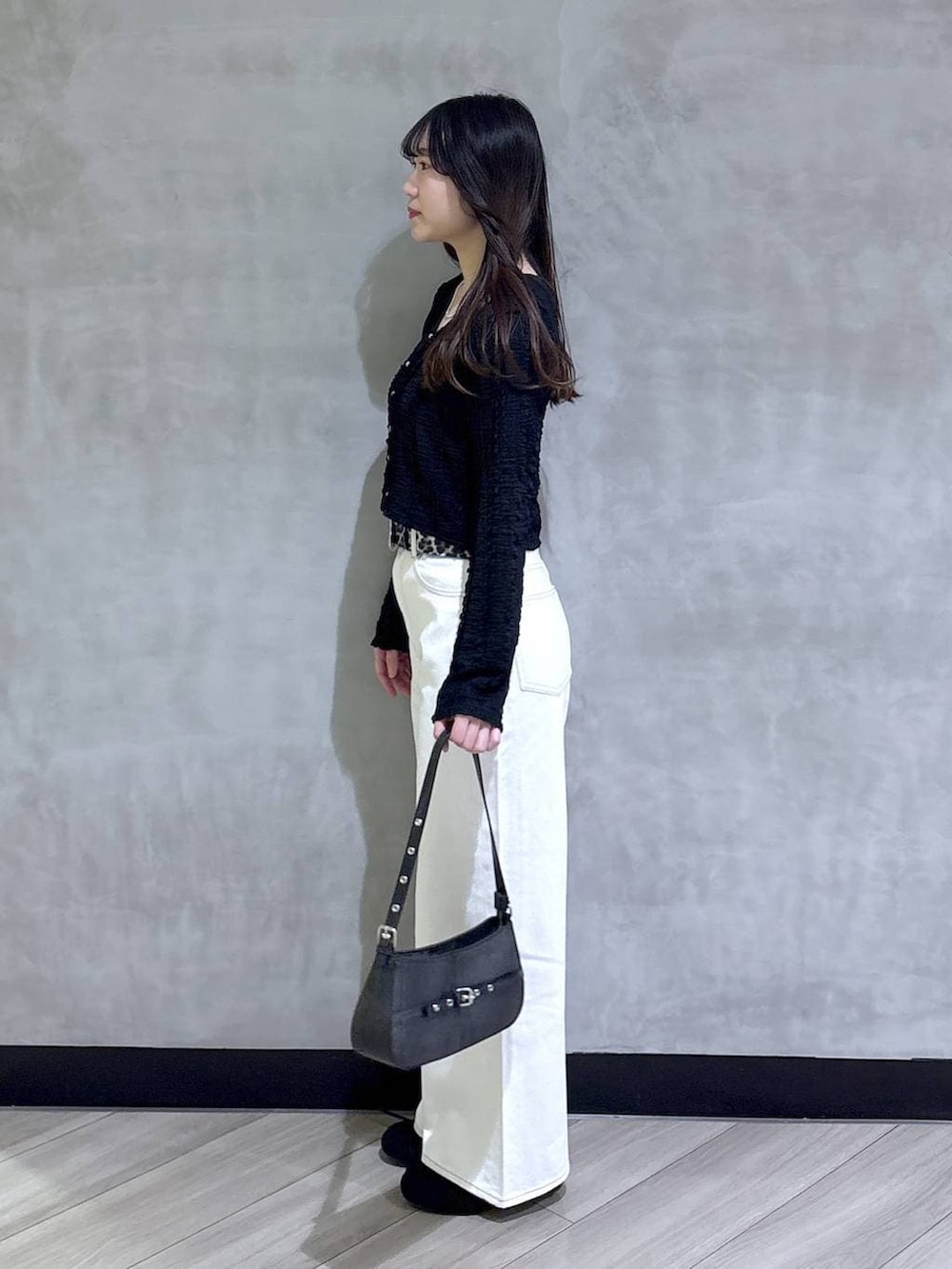 ブルー系のスラックス、ブラック系のハンドバッグ、ブラック系のモカシン/デッキシューズを着用したレディースの春コーディネートの3枚目の写真