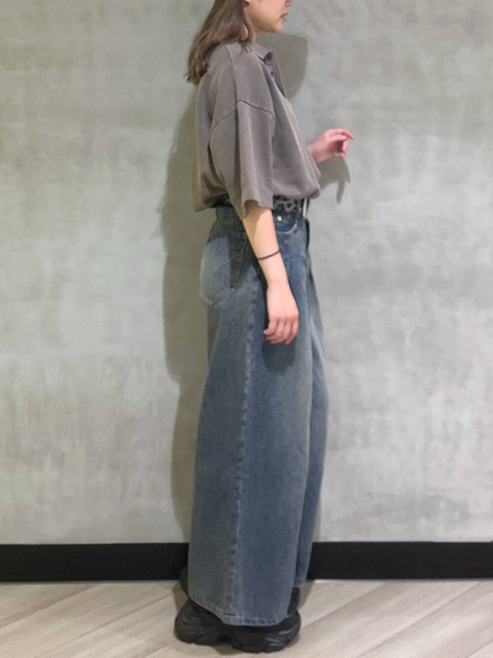 ブルー系のデニムパンツ、ブラウン系のスウェット、シルバー系のスニーカーを着用したレディースの夏コーディネートの7枚目の写真