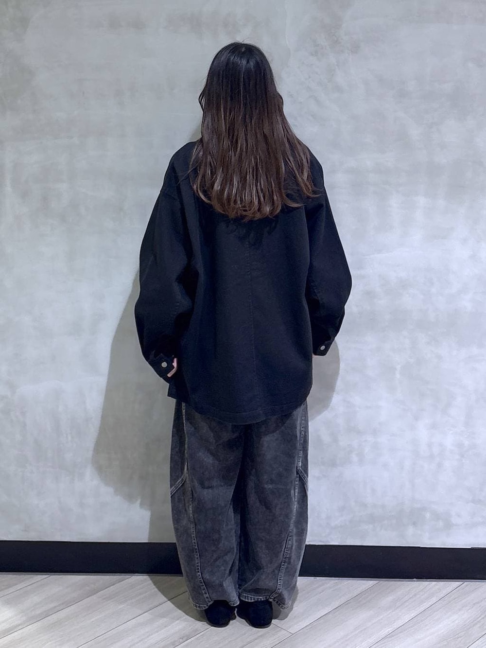 ブラック系のデニムパンツ、ブラック系のモカシン/デッキシューズ、ブラック系のその他アウターを着用したレディースの春コーディネートの5枚目の写真