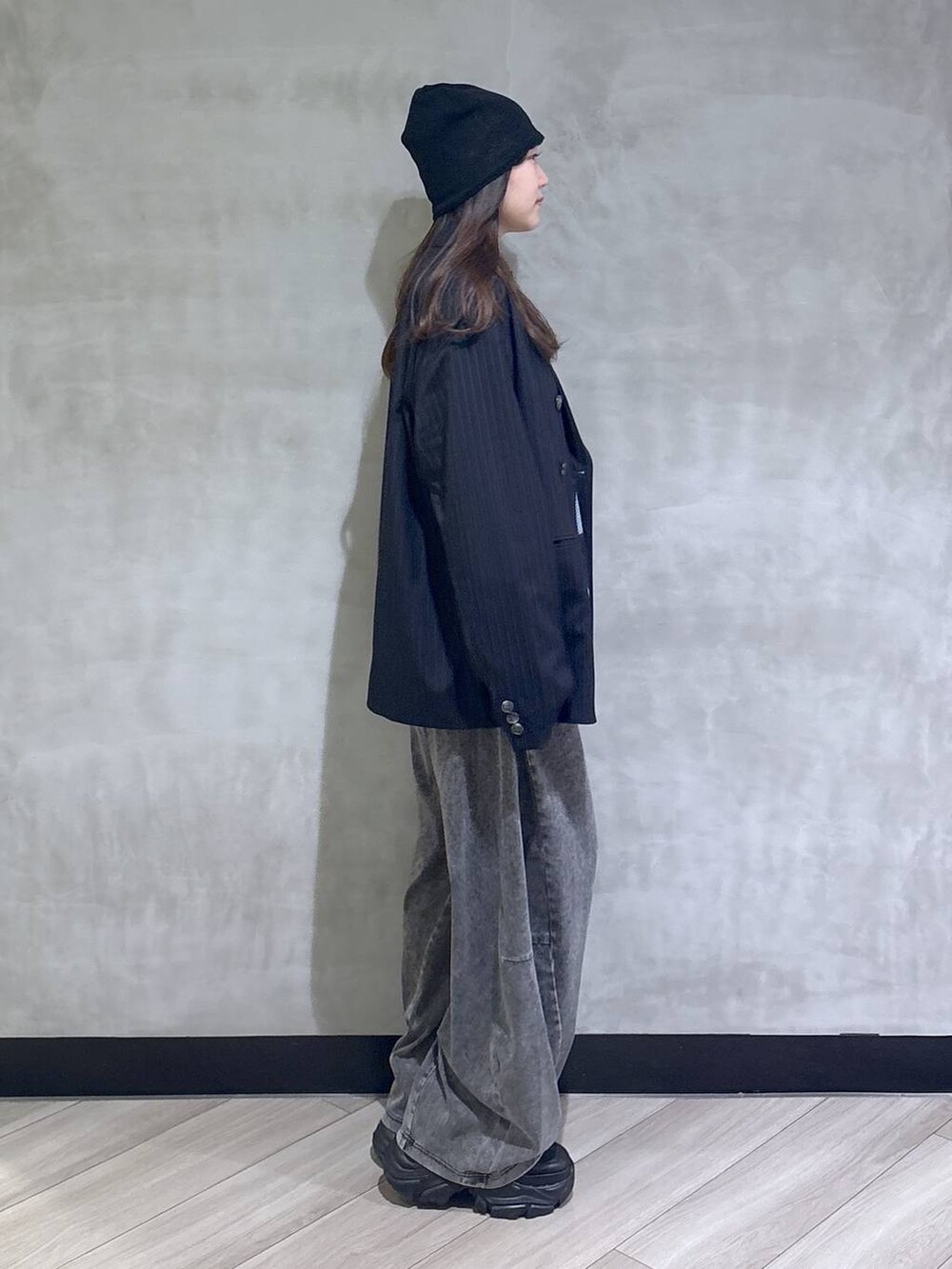 ブラック系のスニーカー、ブラック系のデニムパンツ、ブルー系のテーラードジャケットを着用したレディースの春コーディネートの6枚目の写真