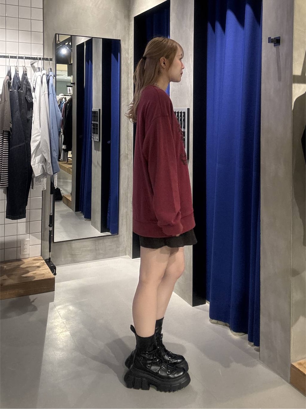 ブラック系のブーツ、レッド系のスウェット、ブラック系のその他パンツを着用したレディースの秋コーディネートの6枚目の写真