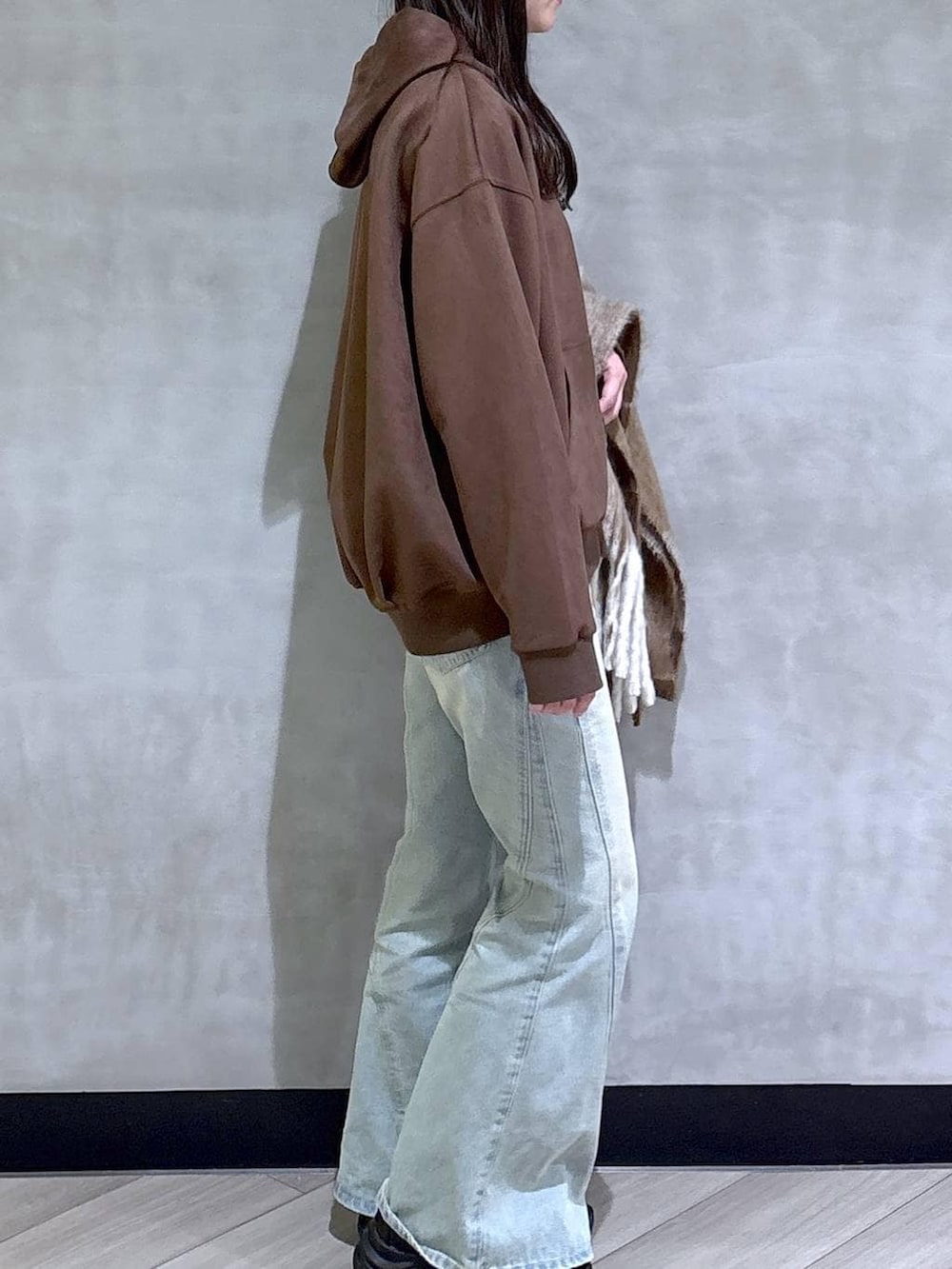 ブルー系のデニムパンツ、ブラック系のパーカー、ブラック系のローファーを着用したレディースの冬コーディネートの8枚目の写真