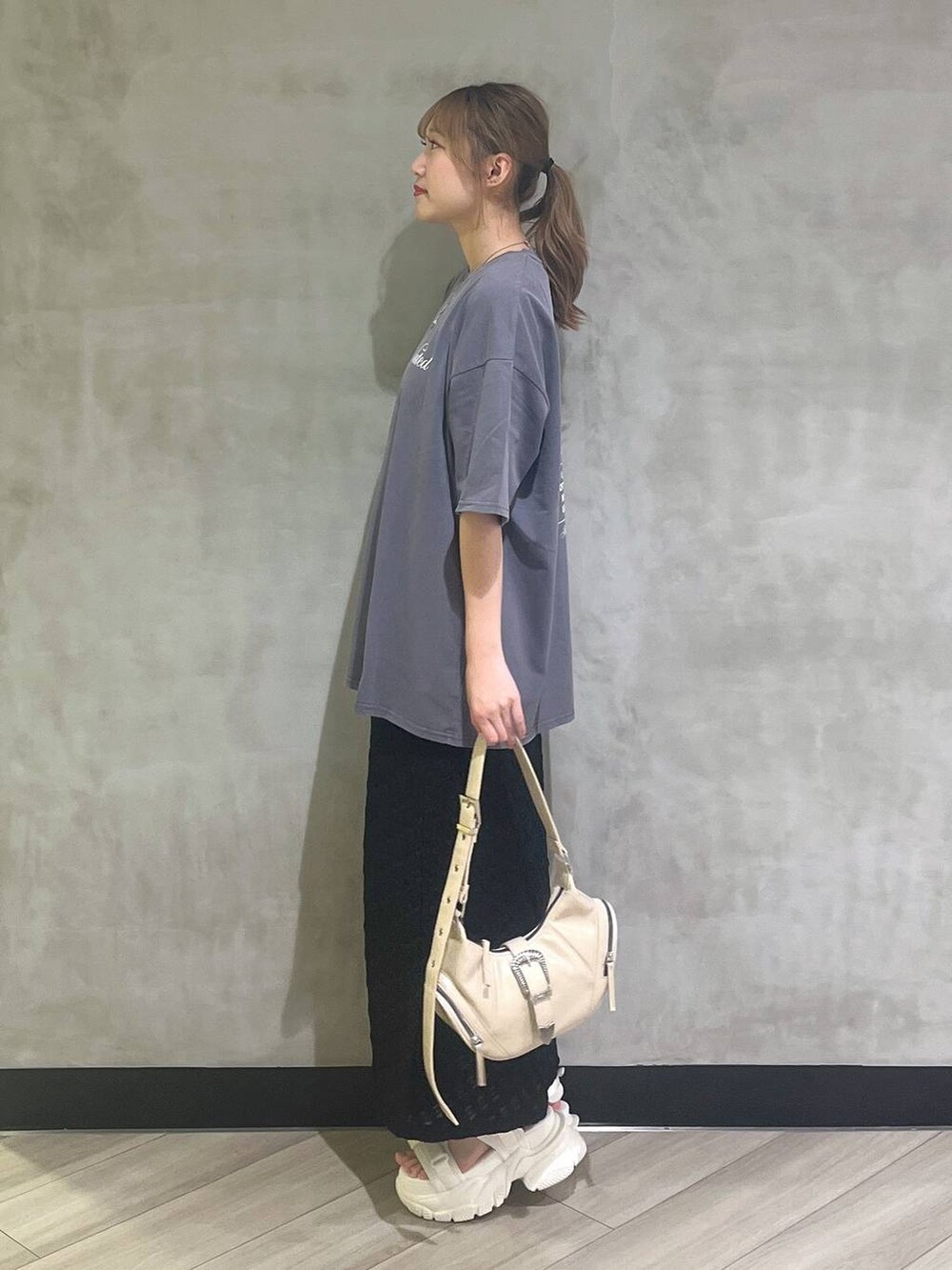 ホワイト系のサンダル、ブラック系のスカート、グレー系のTシャツ/カットソーを着用したレディースの夏コーディネートの3枚目の写真