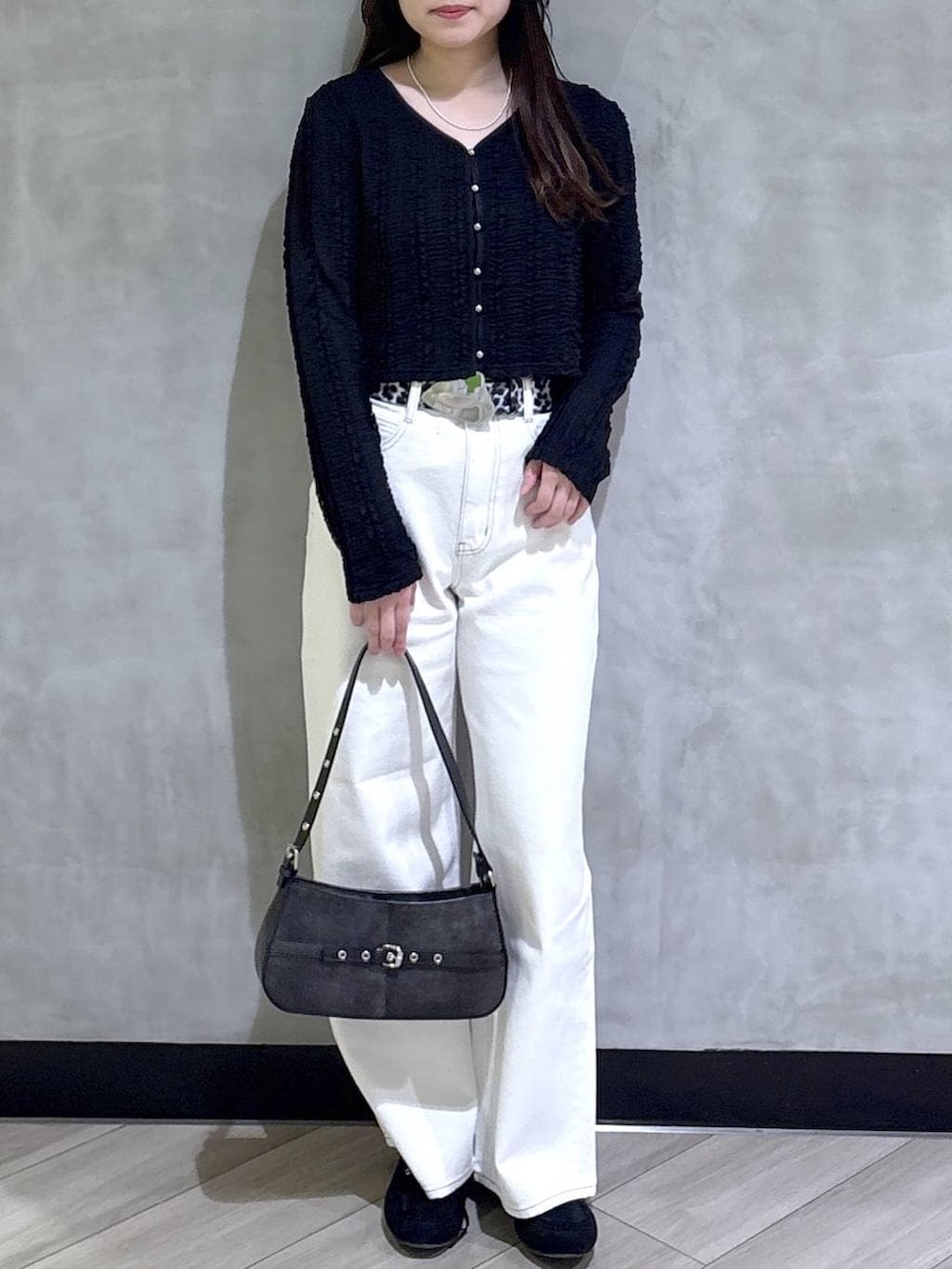 ブルー系のスラックス、ブラック系のハンドバッグ、ブラック系のモカシン/デッキシューズを着用したレディースの春コーディネートの2枚目の写真