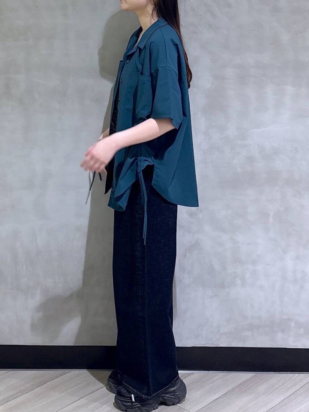 ブルー系のデニムパンツ、ブラック系のサンダル、グリーン系のシャツ/ブラウスを着用したレディースの春コーディネートの4枚目の写真