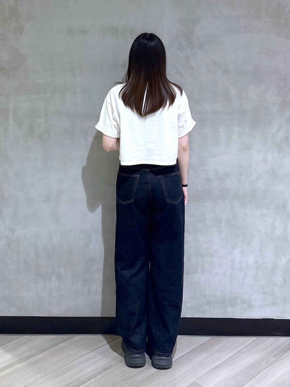 ブラック系のスニーカー、ブルー系のデニムパンツ、ホワイト系のTシャツ/カットソーを着用したレディースの夏コーディネートの5枚目の写真